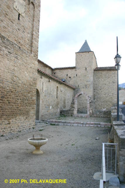 Eglise Sainte Marie de Corneilla de Conflent - Façade sud : Au fond, l'ancienne chapelle du cloître dont il ne reste qu'un arc en marbre rose.