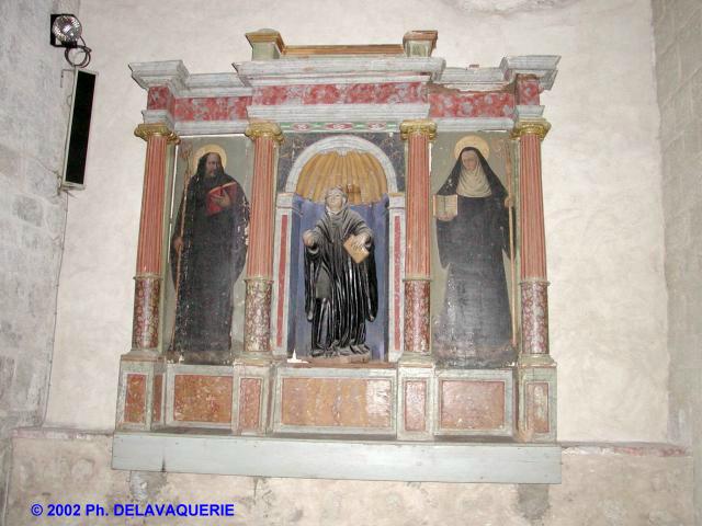 Eglise Saint-Michel de Saint-Genis des Fontaines - Autel-retable (1590) en bois peint avec la statue de St Michel au centre et de part et d'autre, deux personnages peints, St Benoît et Ste Scholastique. 